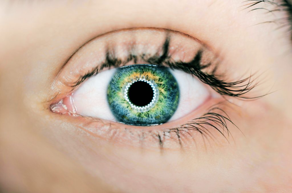 person showing green and black eyelid closeup photography